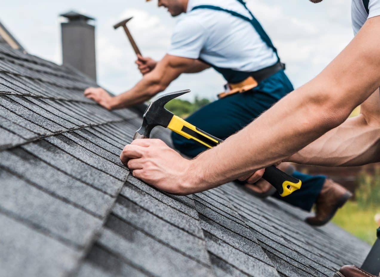 Selective Focus Of Handsome Handyman Repairing Roof With Coworker