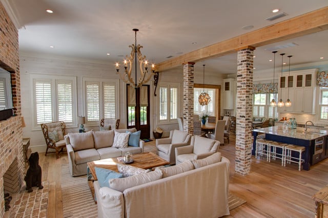 A living room with wood beams and a fireplace.