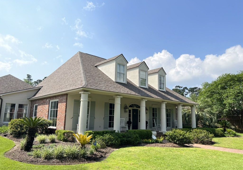 A home with a front porch and shingles.